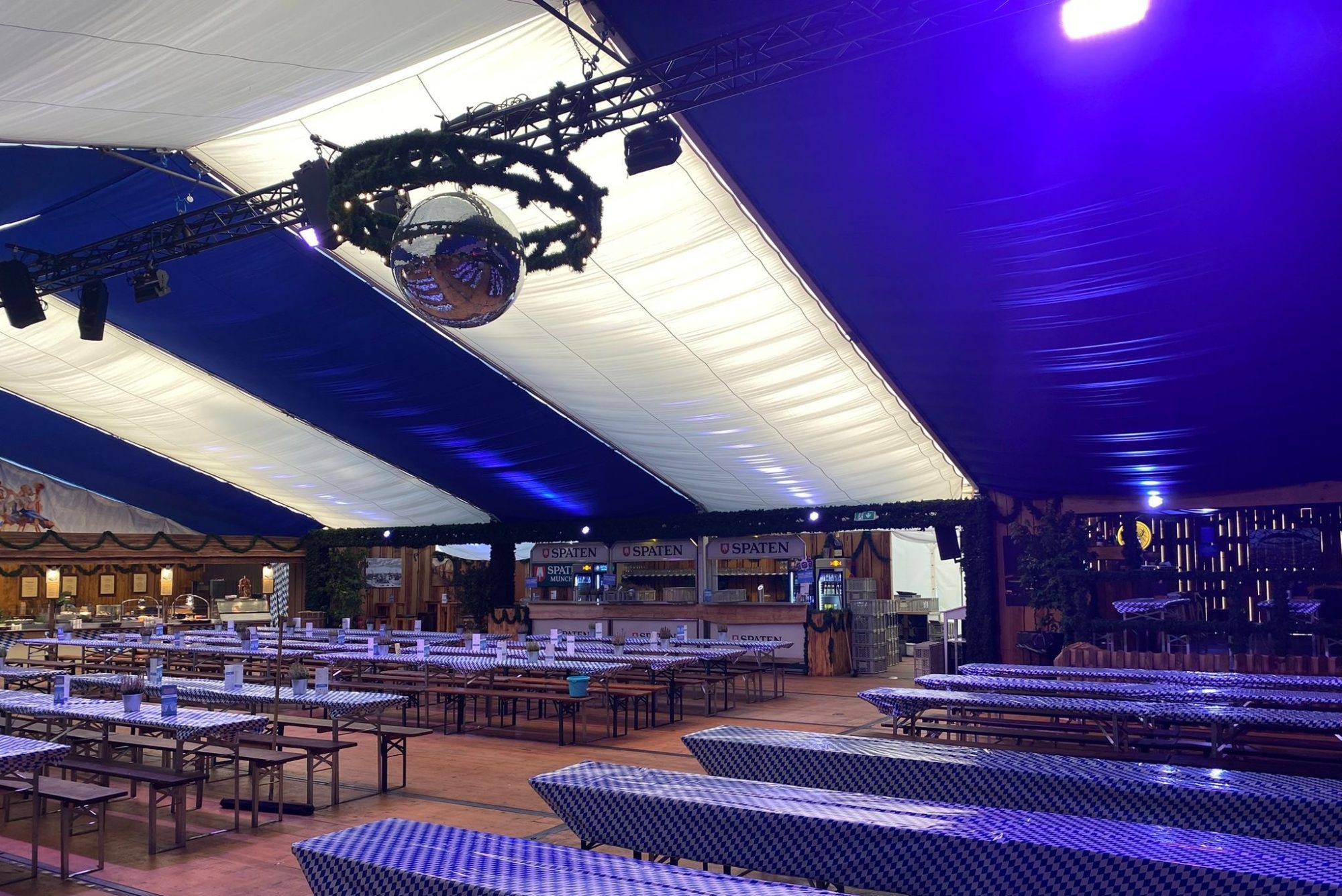 Innenansicht des Oktoberfest-Zelts in Hamburg von Tent Dimensions: große Festzeltstruktur mit Holzverkleidung und langen Biertischen im traditionellen Stil.