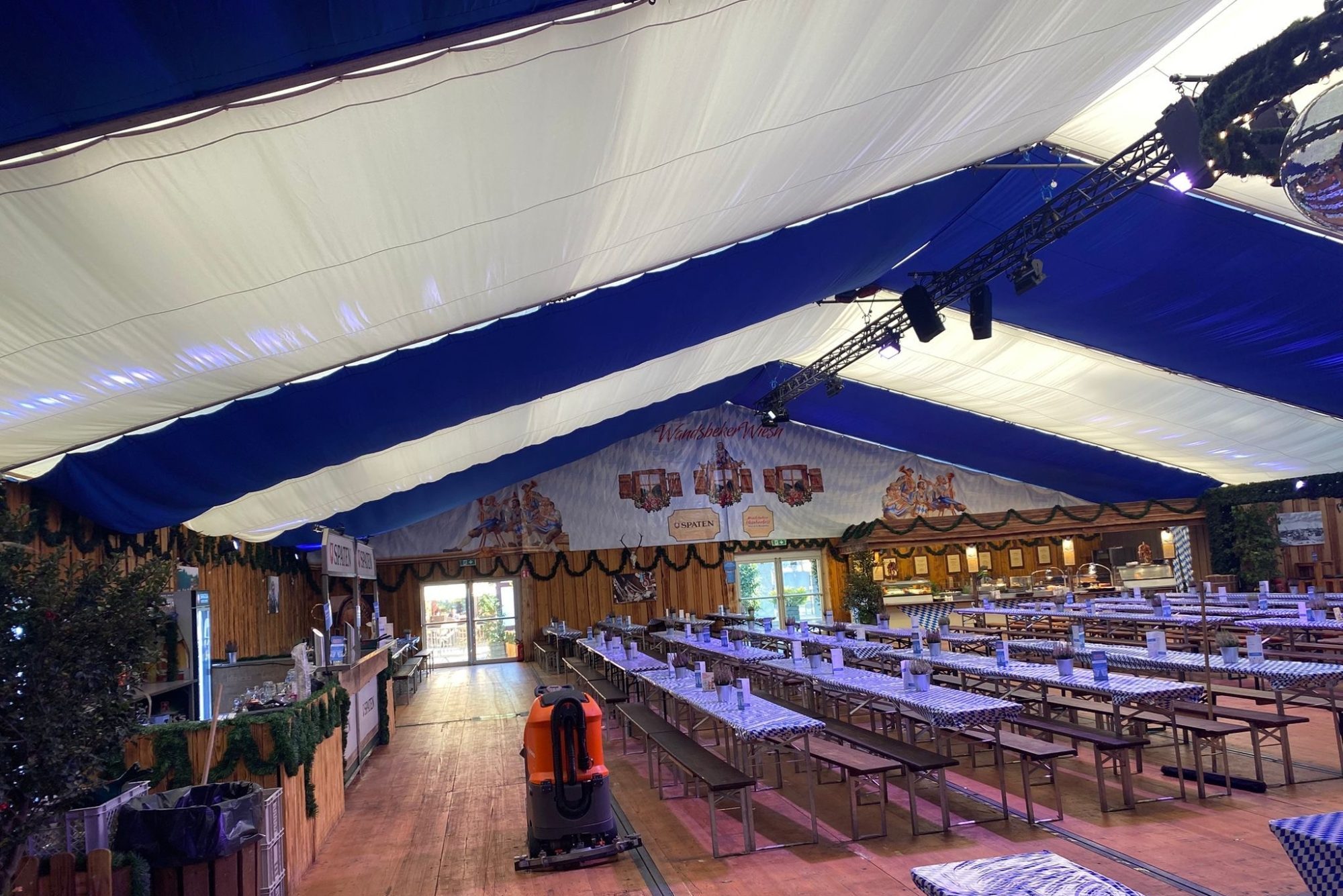 Blick ins Festzelt beim Oktoberfest Hamburg: rustikales Eventzelt mit Holzverkleidung, typischen Biertischen und festlicher Dekoration.